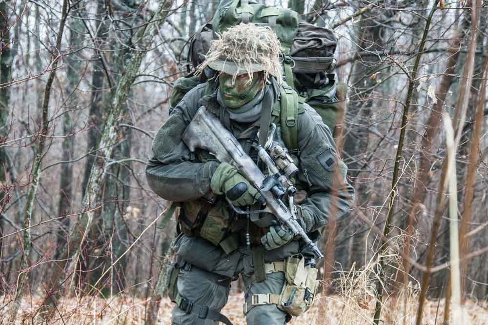 Soldat einer taktischen Einheit mit Sturmgewehr im Wald